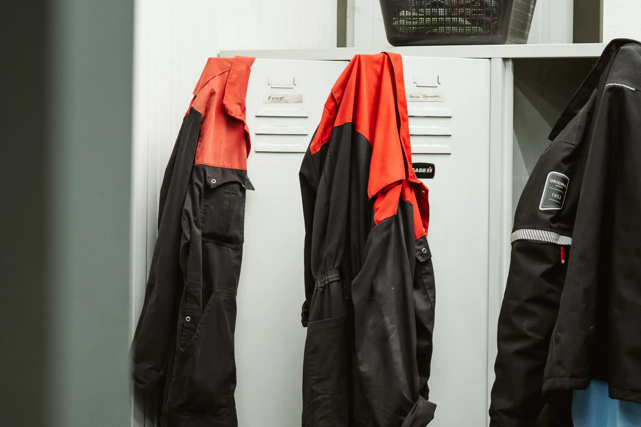 Rood-zwarte werkoveralls aan de kluisjes in de kleedruimte.